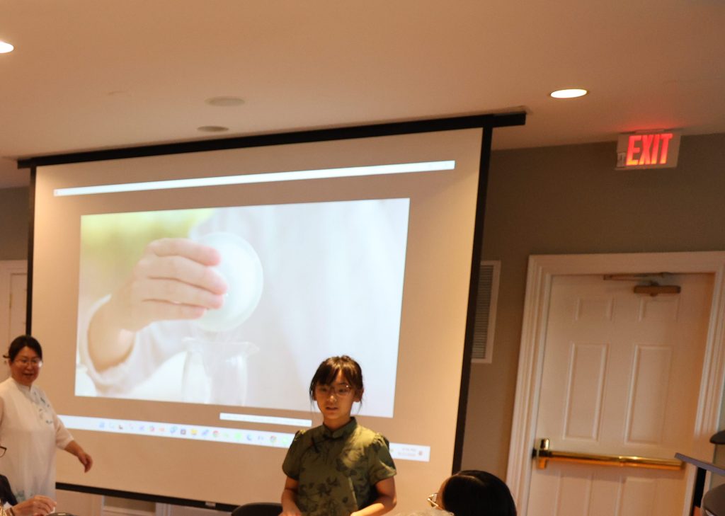 A presenter introduces Chinese tea culture to participants during a workshop at Wellness House.