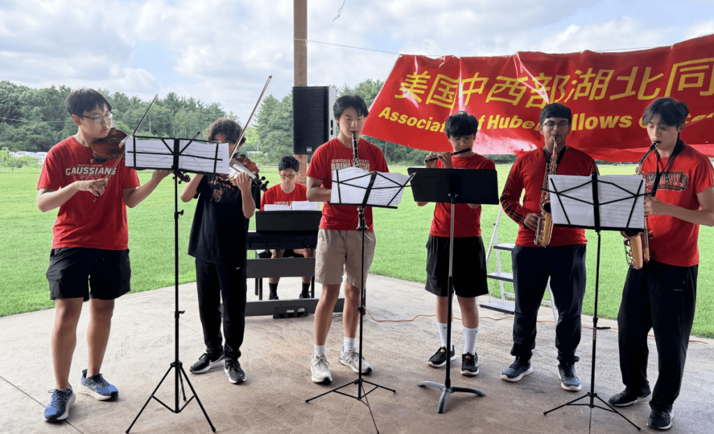Red Dragon Band members performing outdoors at an event hosted by the Hubei Association in the Chicago area.